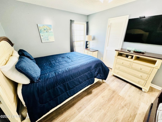 bedroom with light hardwood / wood-style flooring, a closet, and a textured ceiling