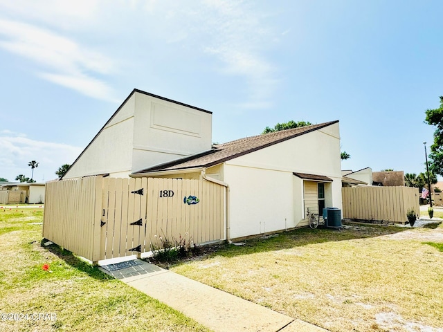 view of outdoor structure with central AC and a yard