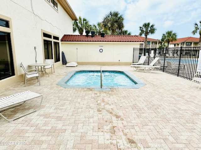 view of pool featuring a patio area and a community hot tub