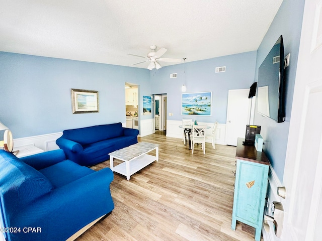 living room with light hardwood / wood-style flooring and ceiling fan