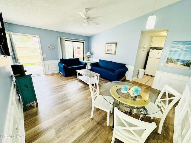 tiled dining room featuring ceiling fan, a textured ceiling, and lofted ceiling