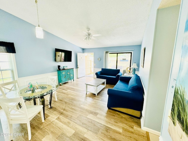 living room with vaulted ceiling, light hardwood / wood-style floors, and ceiling fan