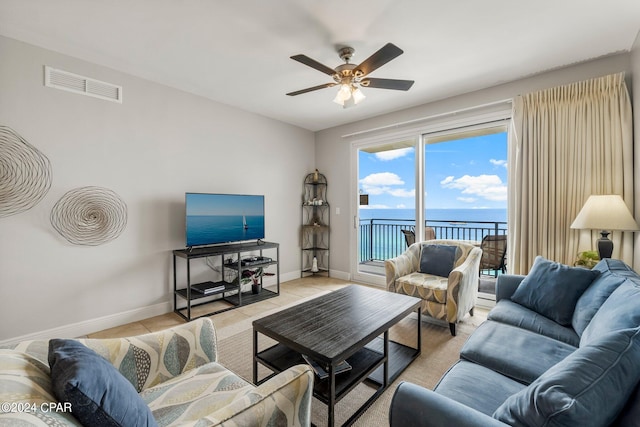 living room with ceiling fan, carpet floors, and a water view