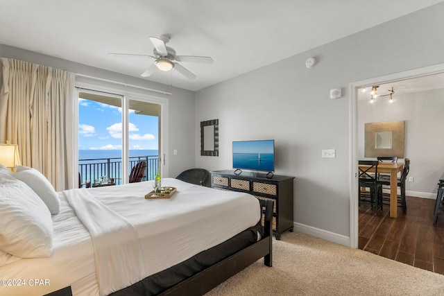 bedroom with ceiling fan, a water view, access to exterior, and dark wood-type flooring