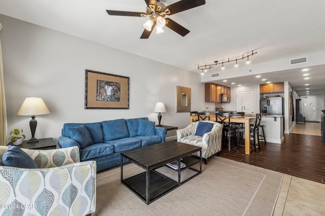 kitchen featuring light stone countertops, dark hardwood / wood-style flooring, black appliances, kitchen peninsula, and sink