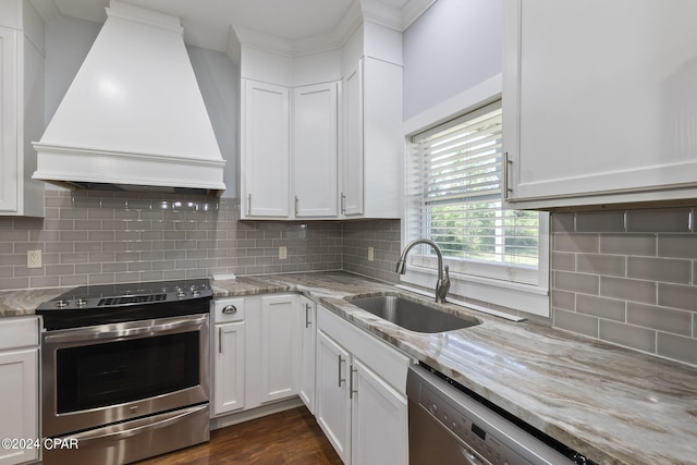 kitchen featuring stainless steel electric range, sink, custom range hood, and white cabinets