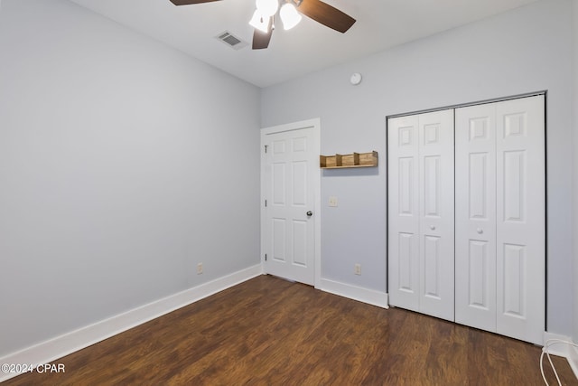 unfurnished bedroom featuring ceiling fan, dark hardwood / wood-style floors, and a closet