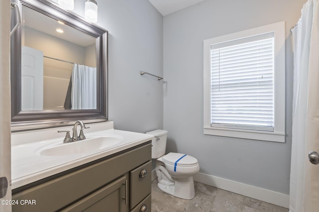 bathroom featuring vanity, toilet, and curtained shower