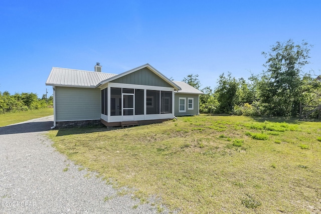 back of house featuring a yard and a sunroom