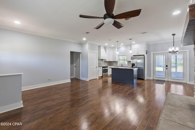 unfurnished living room featuring dark hardwood / wood-style floors, ceiling fan with notable chandelier, sink, ornamental molding, and french doors