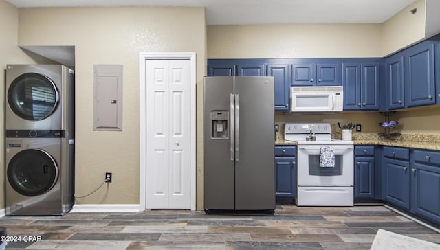 kitchen featuring white appliances, electric panel, blue cabinetry, light stone countertops, and stacked washer and dryer