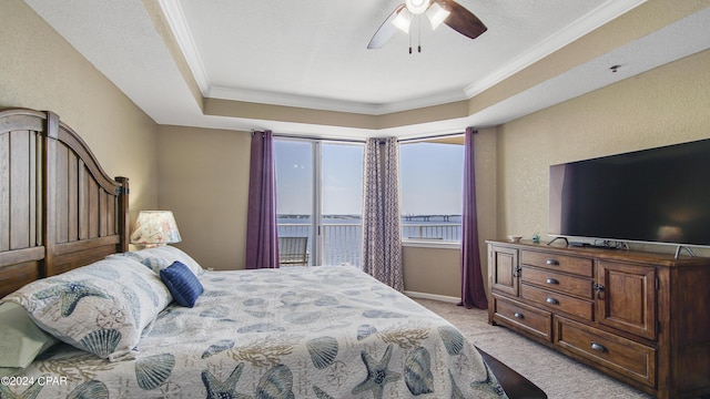 carpeted bedroom featuring a raised ceiling, ceiling fan, crown molding, and access to outside