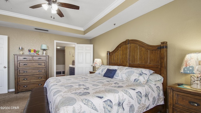 carpeted bedroom with ceiling fan, ornamental molding, a raised ceiling, and connected bathroom