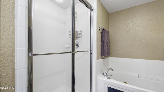 bathroom with separate shower and tub and a textured ceiling