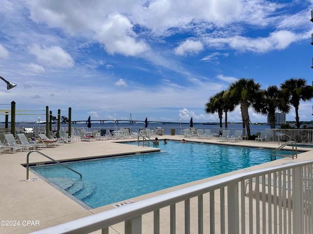 view of pool featuring a patio and a water view