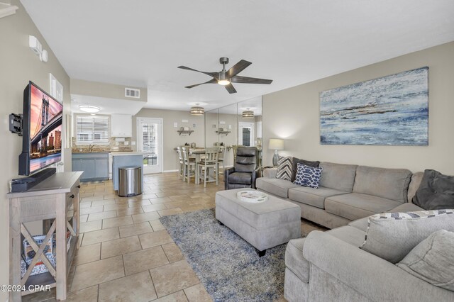 tiled living room with sink and ceiling fan