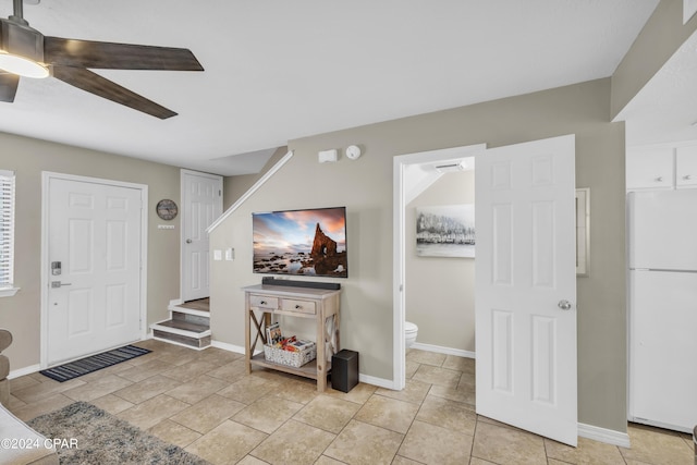 tiled foyer featuring ceiling fan