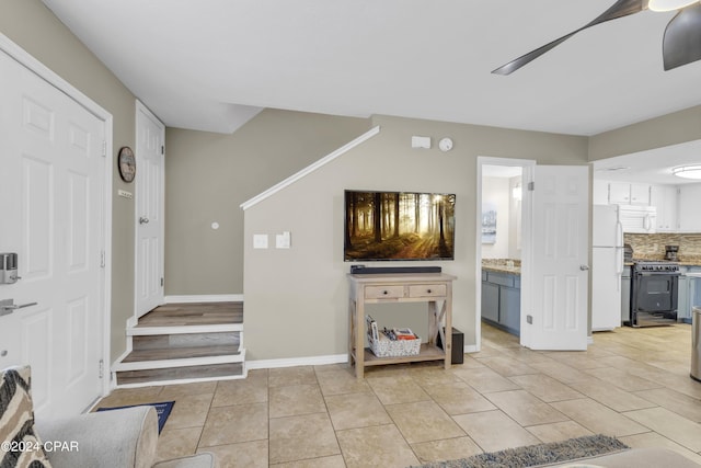 entryway featuring light tile patterned floors and ceiling fan