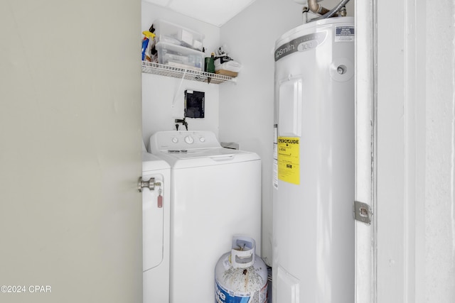 clothes washing area featuring washing machine and clothes dryer and water heater