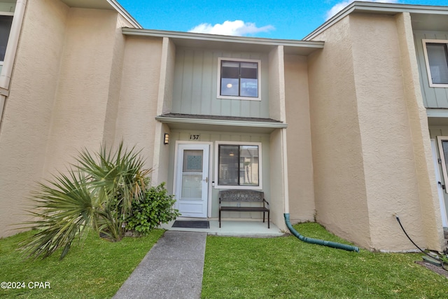 entrance to property with a lawn