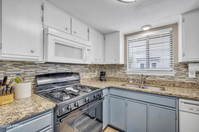 kitchen featuring tasteful backsplash, white cabinetry, sink, and white appliances