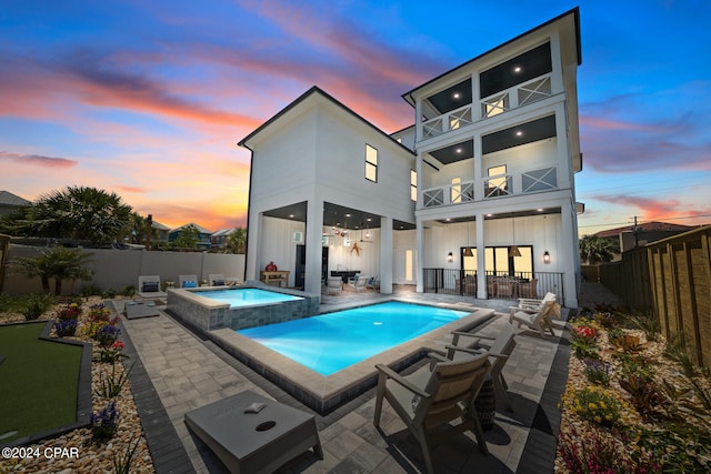 exterior space featuring an in ground hot tub and a patio area