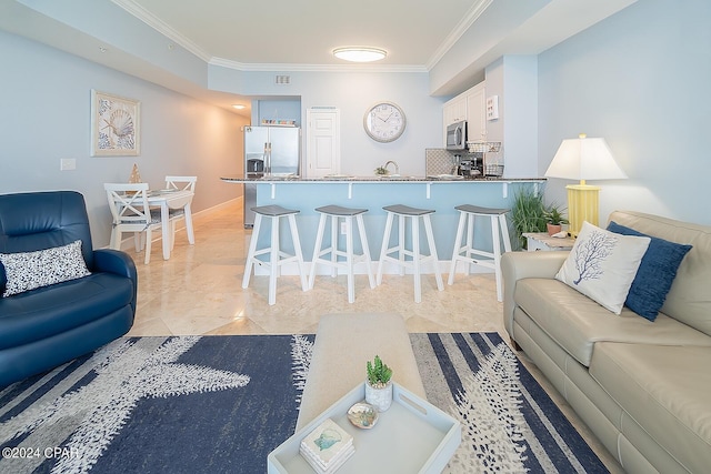 living room with sink, crown molding, and light tile floors