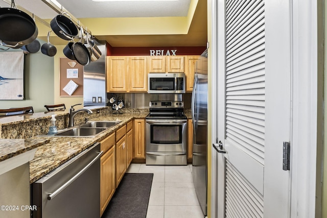 kitchen with stainless steel appliances, light tile floors, and sink