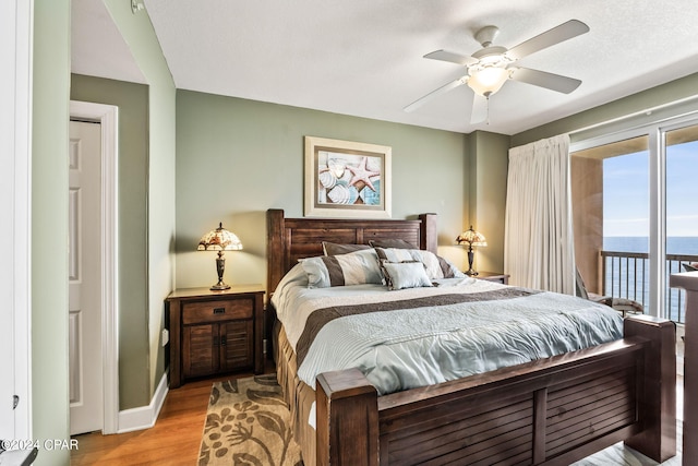 bedroom with light hardwood / wood-style flooring, ceiling fan, access to outside, and multiple windows