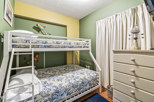 bedroom featuring a textured ceiling and hardwood / wood-style floors