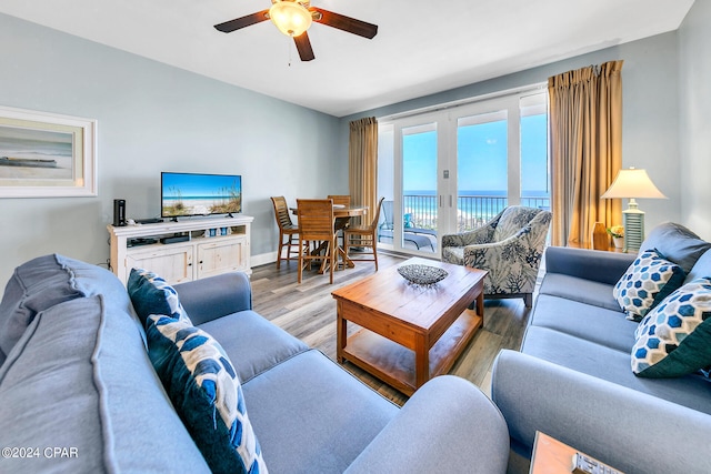 living area with french doors, wood finished floors, a ceiling fan, and baseboards