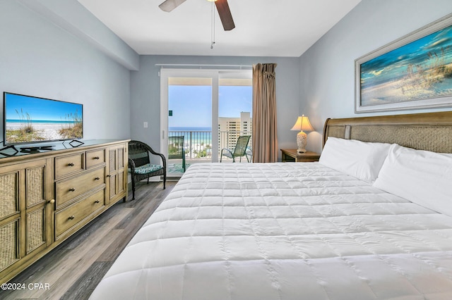 bedroom with access to outside, a water view, ceiling fan, and wood finished floors