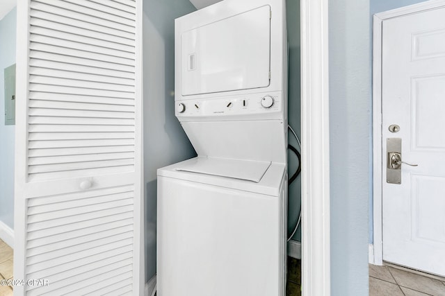 laundry room featuring stacked washer / dryer, laundry area, and light tile patterned floors