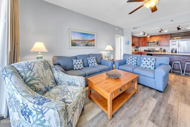 living room with light hardwood / wood-style flooring and ceiling fan