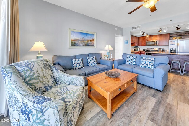 living room with ceiling fan and hardwood / wood-style flooring