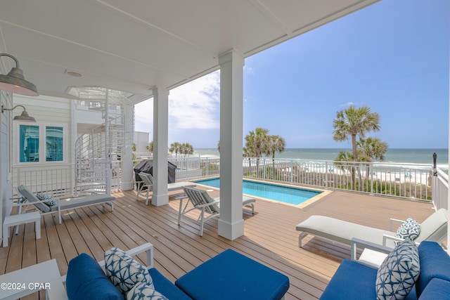 deck featuring a fenced in pool and a water view