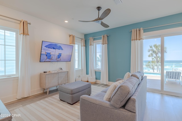 living room featuring a healthy amount of sunlight, light hardwood / wood-style flooring, and ceiling fan