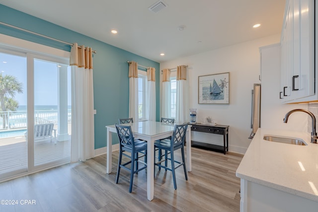 dining room featuring a wealth of natural light, light hardwood / wood-style flooring, and sink