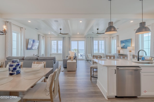 kitchen featuring dishwasher, beamed ceiling, wood-type flooring, white cabinets, and sink