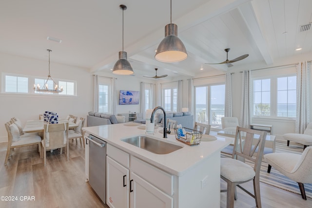 kitchen featuring beamed ceiling, light hardwood / wood-style flooring, a center island with sink, sink, and dishwasher