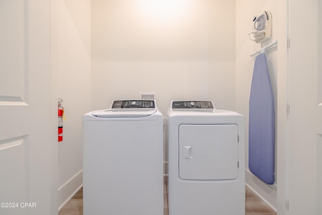 laundry room featuring washer hookup, light hardwood / wood-style floors, and separate washer and dryer