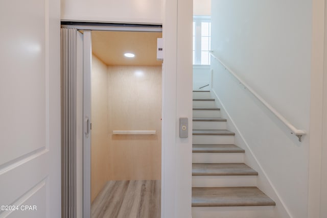 stairs featuring hardwood / wood-style floors and elevator