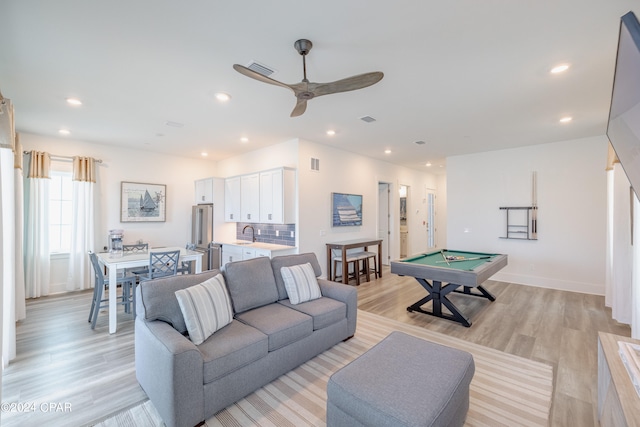 living room with sink, light hardwood / wood-style floors, ceiling fan, and pool table