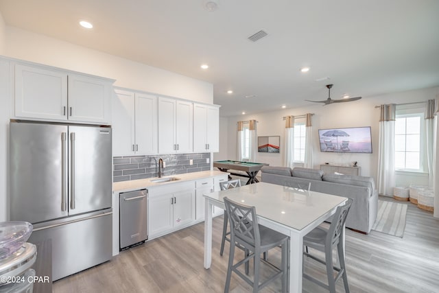 kitchen with a healthy amount of sunlight, appliances with stainless steel finishes, pool table, and light wood-type flooring