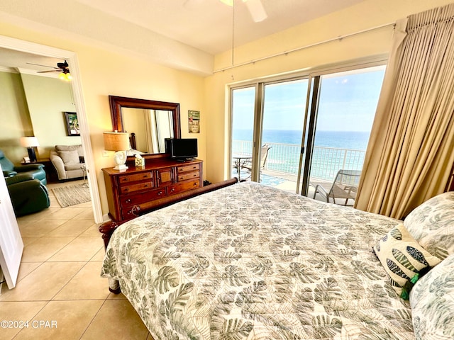 tiled bedroom featuring ceiling fan, access to exterior, and a water view