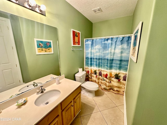 bathroom with vanity with extensive cabinet space, toilet, tile floors, and a textured ceiling