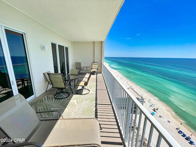 balcony with a water view and a beach view