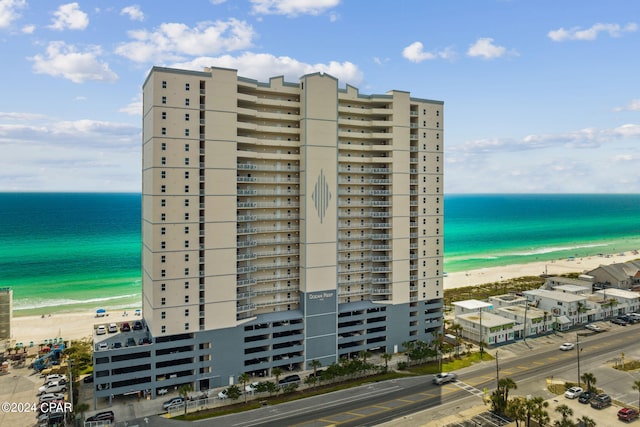 view of building exterior with a water view and a beach view