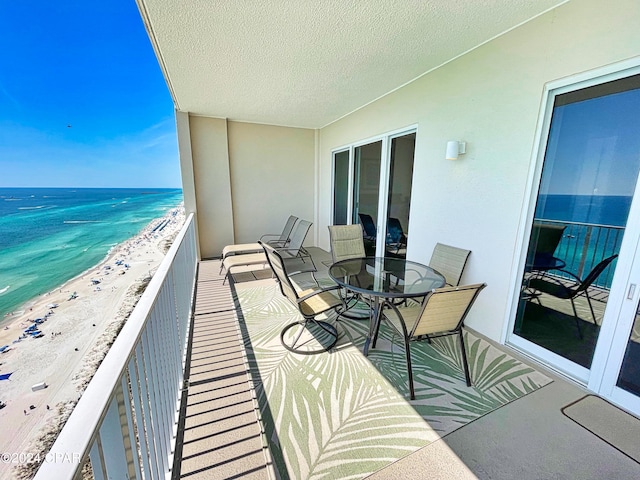 balcony featuring a water view and a view of the beach