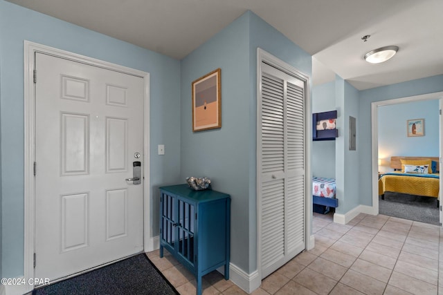 foyer featuring baseboards and light tile patterned floors